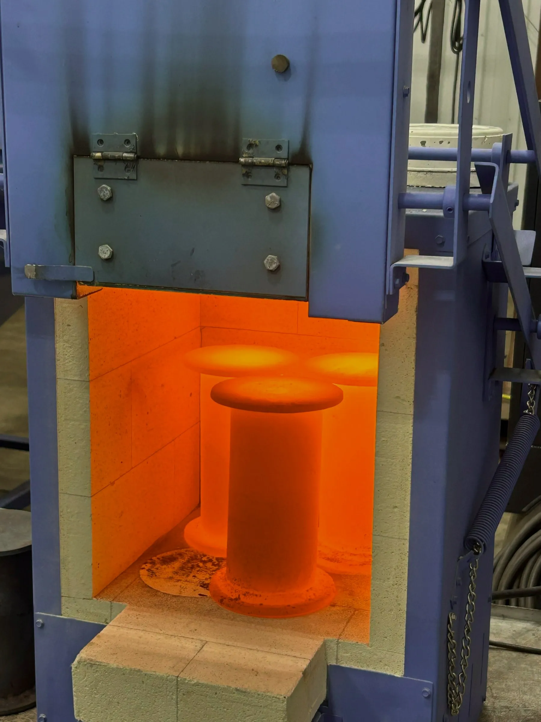 Crucibles glowing orange inside the kilogram-scale graphitization furnace.