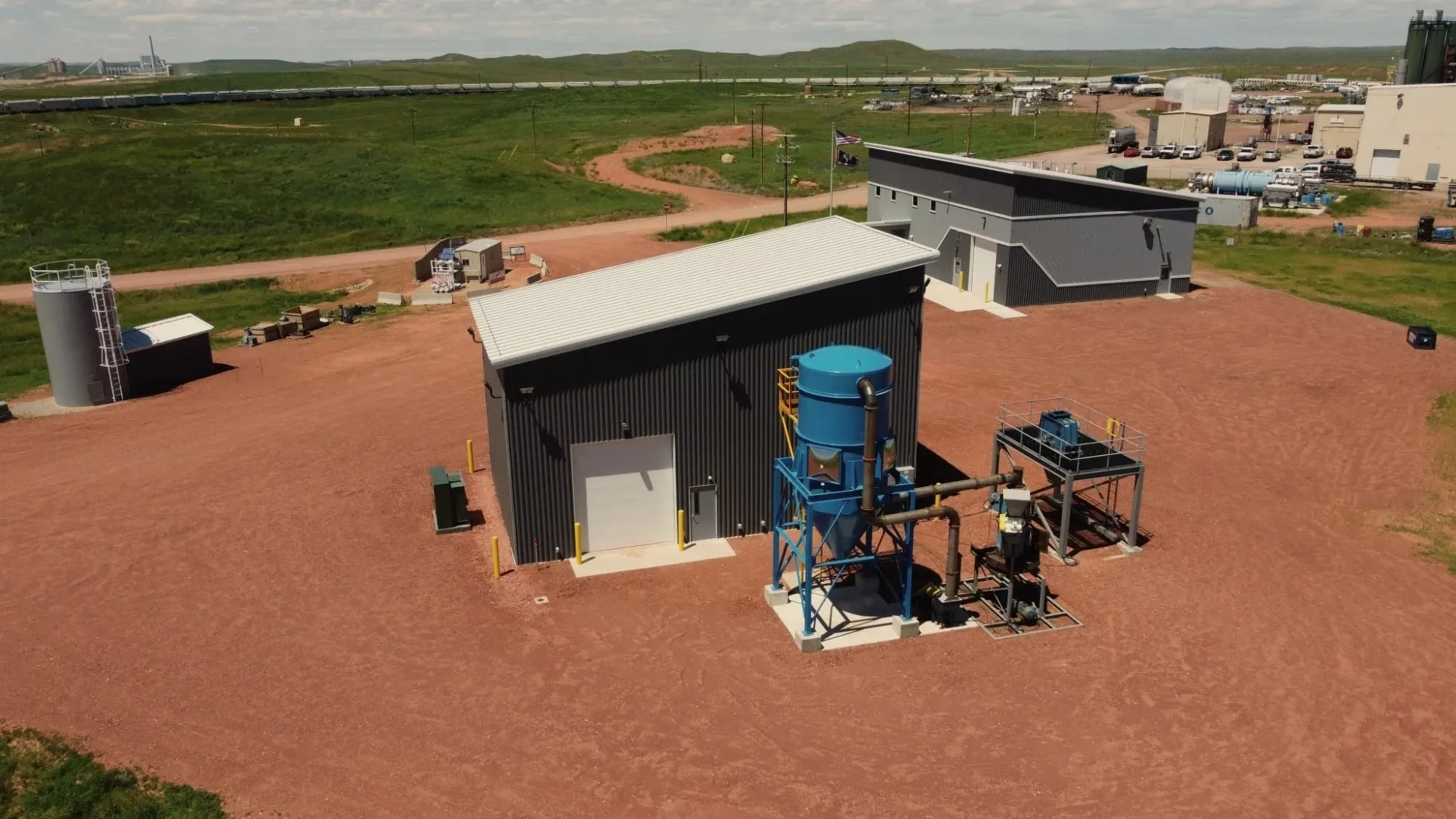 Aerial view of the US Carbon pilot building and process equipment at the Wyoming Innovation Center, with open Wyoming grassland beyond.